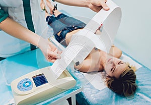 Doctor with electrocardiogram equipment making cardiogram test