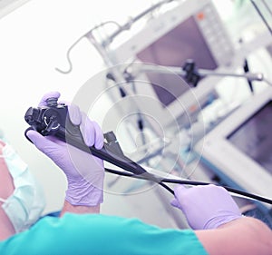 Doctor with endoscopy tool in his hands during procedure photo