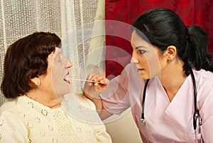 Doctor examine elderly for sore throat
