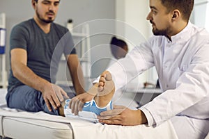 Doctor examine patient with broken leg in orthopedic bandage on hospital bed photo