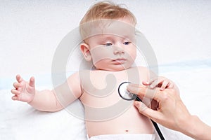 Doctor examines the baby with a stethoscope. Listens to the heart, baby`s lungs