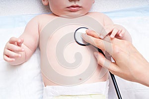 Doctor examines the baby with a stethoscope. Listens to the heart, baby`s lungs