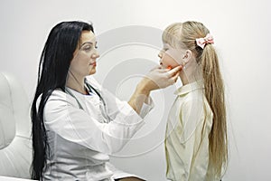 Doctor examines child& x27;s ears and mouth
