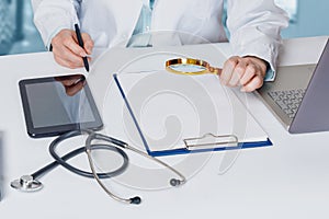 Doctor examines a document with a magnifying glass