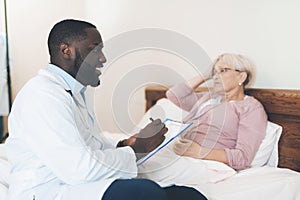 The doctor examines an elderly patient in a nursing home.