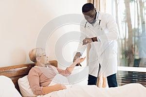 The doctor examines an elderly patient in a nursing home.