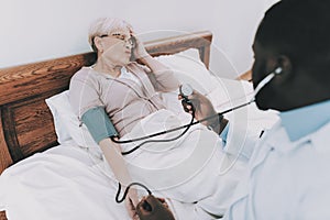 Doctor Examines Elderly Patient. Patient Headache.