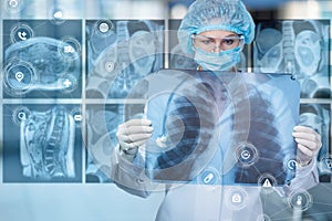 Doctor examines the internal organs from the pictures of the patient on a blurred background