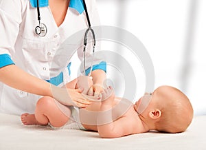 Doctor examines, massaging baby tummy