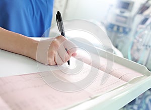 Doctor examines the patient's ECG and writes the description