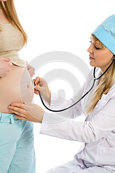 Doctor examines pregnant female using stethoscope