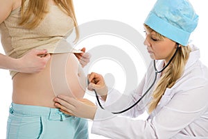 Doctor examines pregnant female using stethoscope