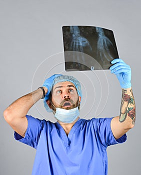 Doctor examines radiographic snapshot. Surgeon estimate damages. Hospital emergency. Doctor uniform. X-ray concept. X