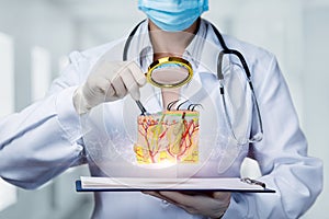 Doctor examines skin model with magnifier