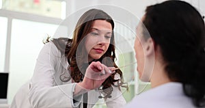 Doctor examines throat of male patient using spatula