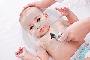 The doctor examining baby with stethoscope