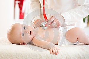 Doctor examining baby with stethoscope in clinic. Baby health concept