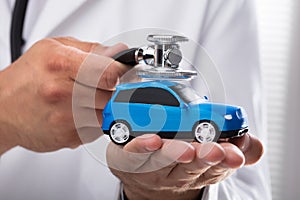 Doctor examining blue car
