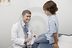 Doctor Examining Boy With Reflex Hammer