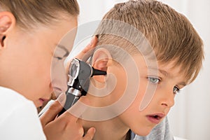 Doctor Examining Boy`s Ear