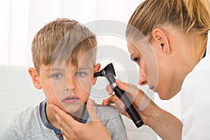 Doctor Examining Boy`s Ear
