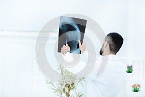 Doctor examining chest x-ray film of patient