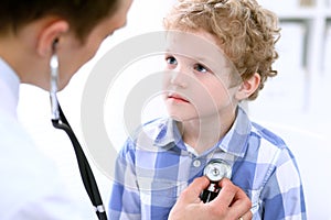 Doctor examining a child patient by stethoscope photo