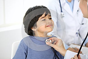 Doctor examining a child patient by stethoscope. Cute arab boy at physician appointment. Medicine and healthcare concept