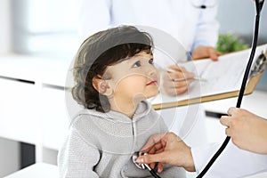 Doctor examining a child patient by stethoscope. Cute arab boy at physician appointment. Medicine and healthcare concept