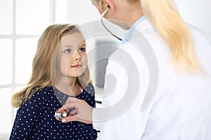 Doctor examining a child patient by stethoscope. Cute baby girl at physician appointment. Medicine concept