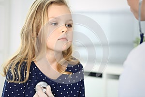 Doctor examining a child patient by stethoscope. Cute baby girl at physician appointment. Medicine concept