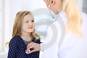 Doctor examining a child patient by stethoscope. Cute baby girl at physician appointment. Medicine concept