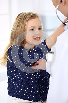 Doctor examining a child patient by stethoscope. Cute baby girl at physician appointment. Medicine concept