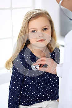 Doctor examining a child patient by stethoscope. Cute baby girl at physician appointment. Medicine concept