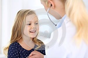 Doctor examining a child patient by stethoscope. Cute baby girl at physician appointment. Medicine concept