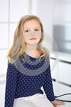 Doctor examining a child patient by stethoscope. Cute baby girl at physician appointment. Medicine concept