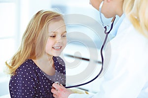 Doctor examining a child patient by stethoscope. Cute baby girl at physician appointment. Medicine concept