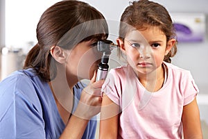 Doctor Examining Child's Ears In Doctor's Office