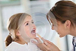 Doctor examining child's throat