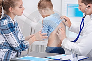 Doctor examining coughing little boy