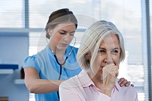 Doctor examining coughing patient