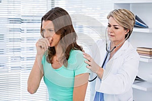 Doctor examining coughing patient with stethoscope