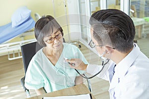 Doctor is examining Elderly woman patient using a stethoscope.