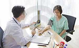 Doctor is examining Elderly woman patient using a stethoscope