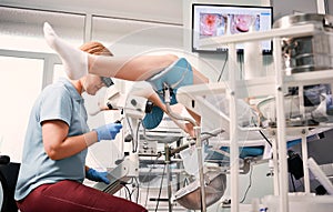 Doctor examining female patient with colposcope. photo