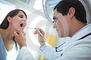 Doctor examining female patients mouth