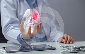 Doctor examining heart with hologram in hand. The concept of using modern technology to help diagnose, treat, and maintain heart