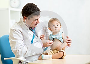 Doctor examining heartbeat of kid boy with