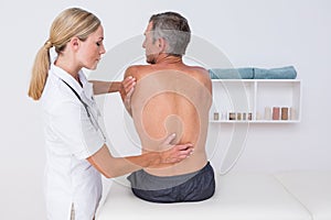 Doctor examining her patient back