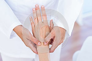 Doctor examining her patients wrist